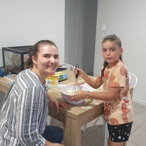 Child being supported to do baking in the kitchen.