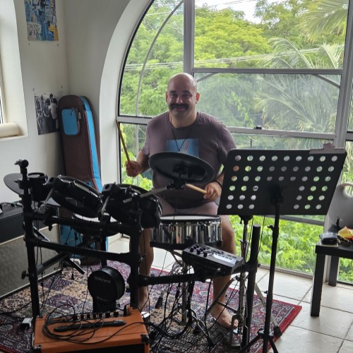 Person being supported to learn new skills with drumming.